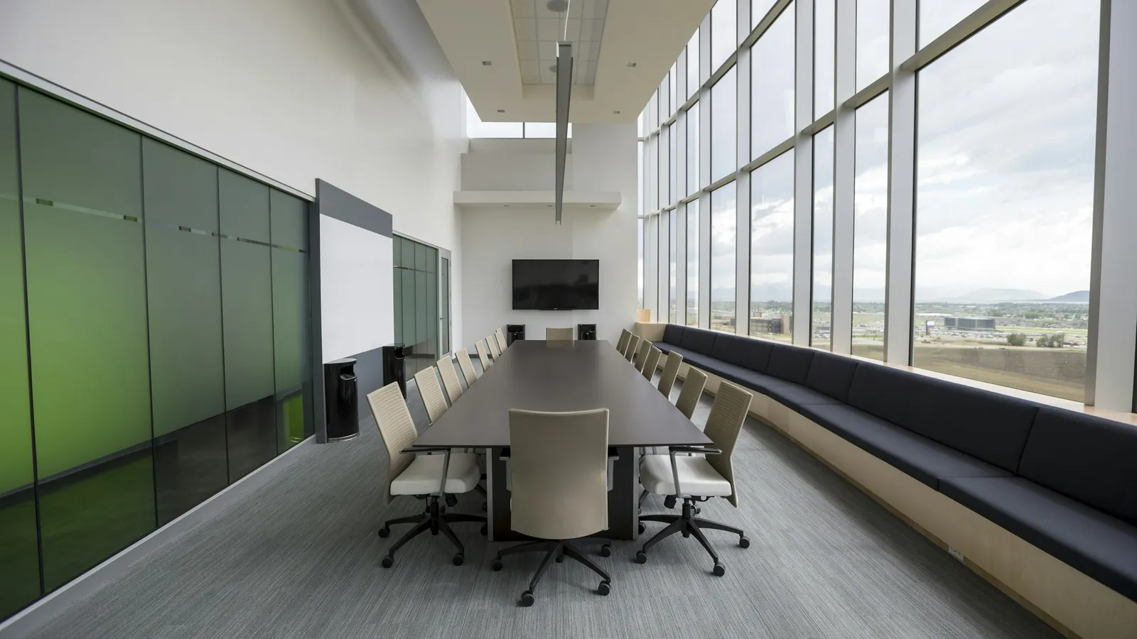 Sala de consejo corporativa vacía con mesa larga y ventanales, junta de acreedores en un concurso mercantil