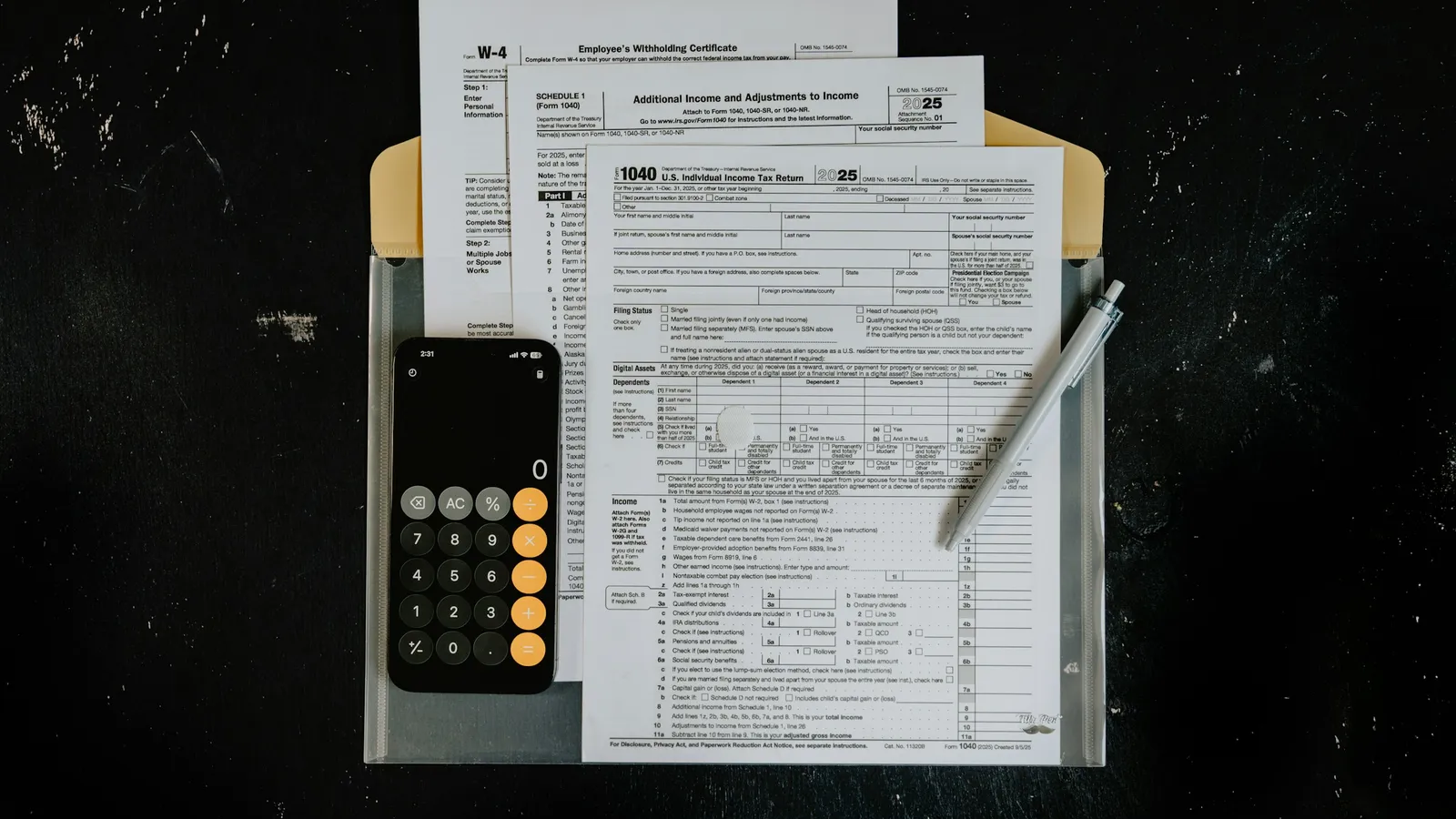 Formularios fiscales, calculadora y pluma sobre un escritorio oscuro, abogado fiscal en Guadalajara