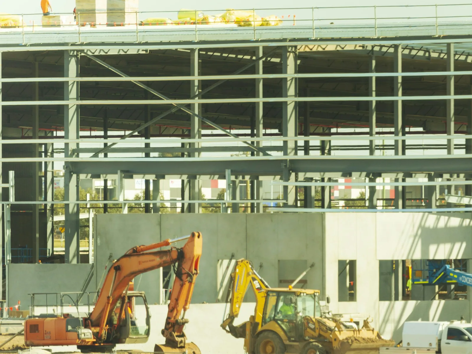 Nave industrial moderna en construcción con estructura de acero, muros de concreto prefabricado y maquinaria, abogado inmobiliario industrial en Guadalajara