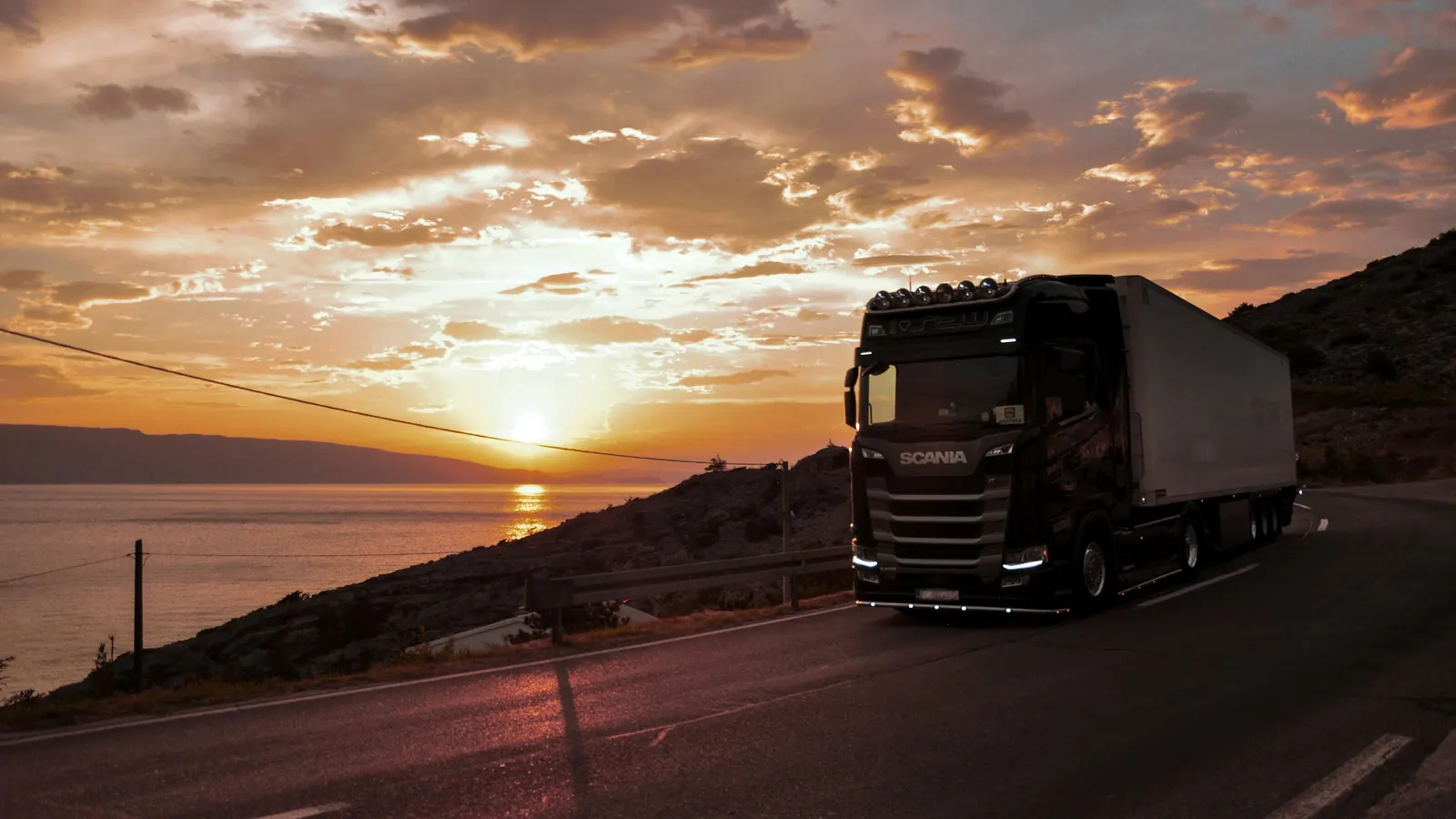 Freight truck on a coastal highway at sunset, supply and distribution contracts in Mexico