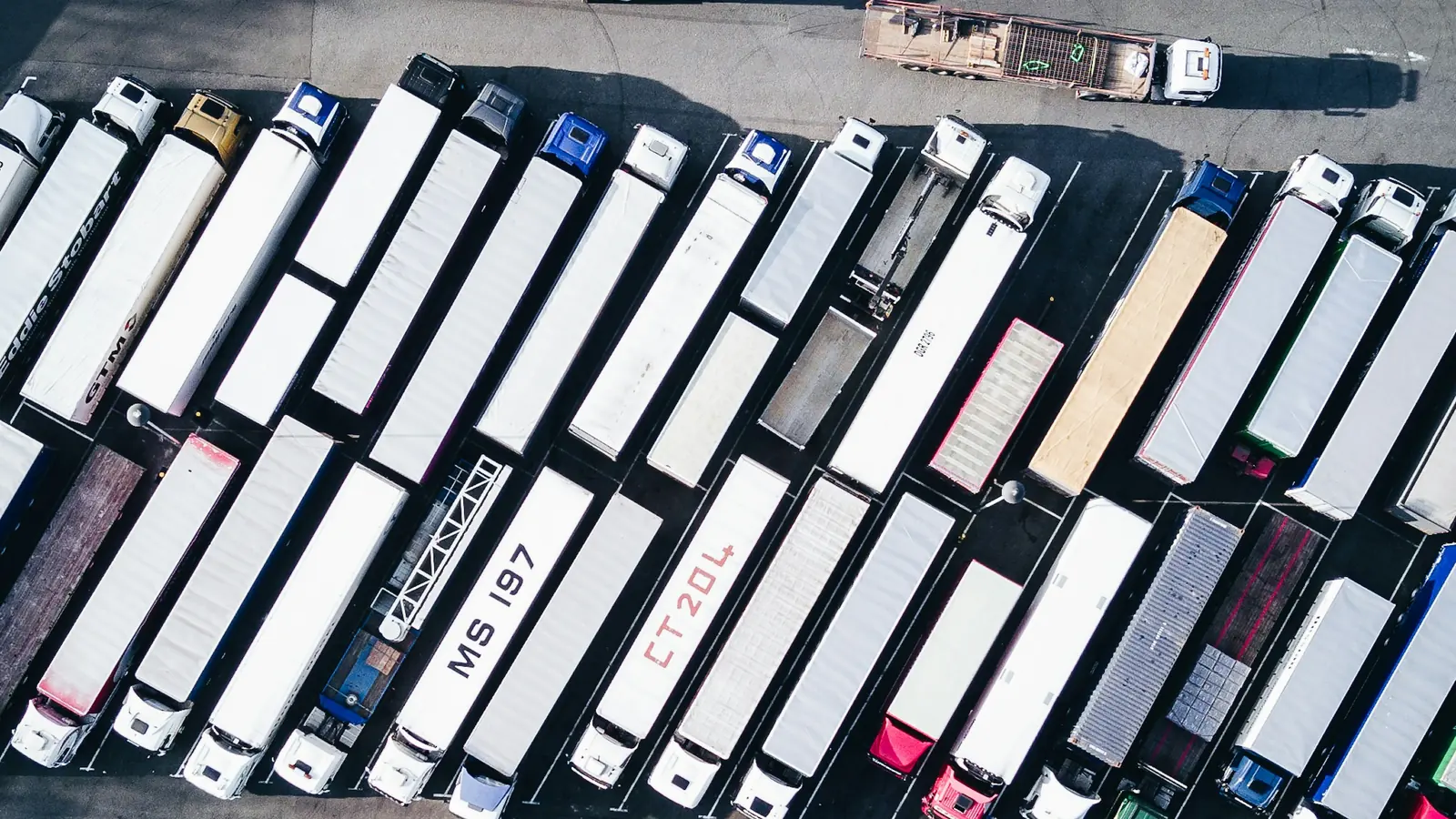 Vista aérea de un patio con decenas de tráileres de carga, cobranza a distribuidores