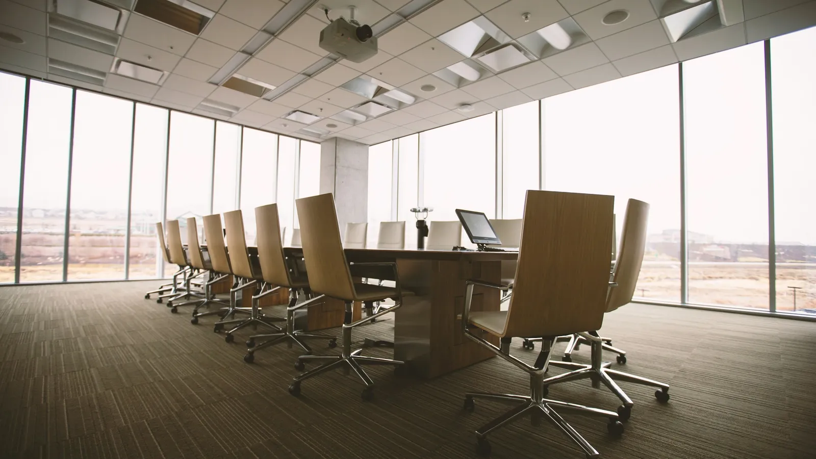 Sala de consejo vacía con ventanales y sillas ejecutivas, abogado corporativo en Guadalajara